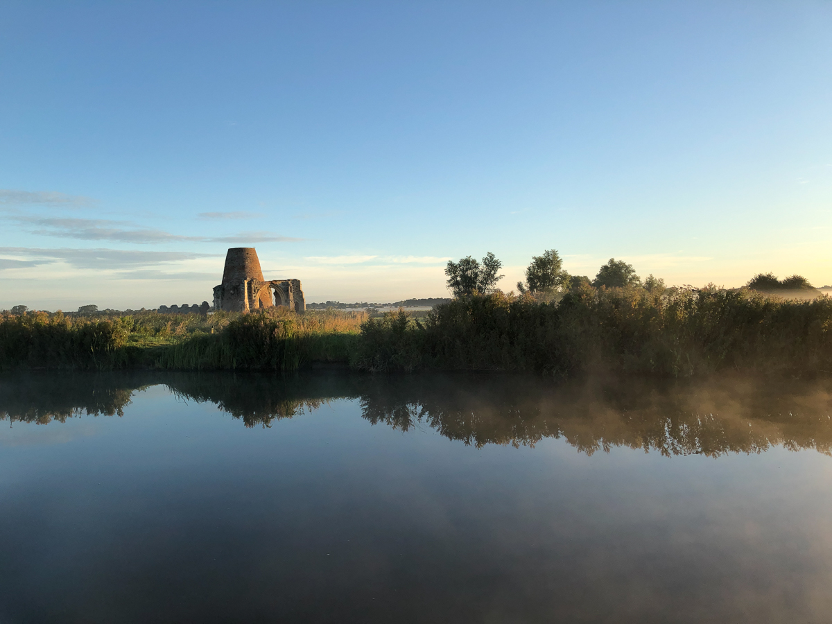 St Benets Abbey with wisps of morning mist over the water