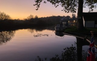 Tied up for the night at Coltishall, smoke rising from an open fire in a house just behind the Rising Sun pub. Fishing rod out for a final half hour.