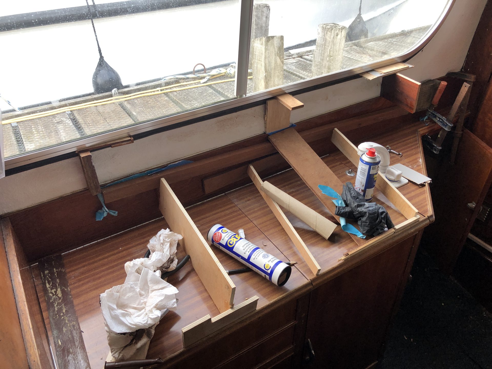 The new splashback being bonded to the galley unit and interior boat side with CT1 using all manner of wedges and wooden offcuts.
